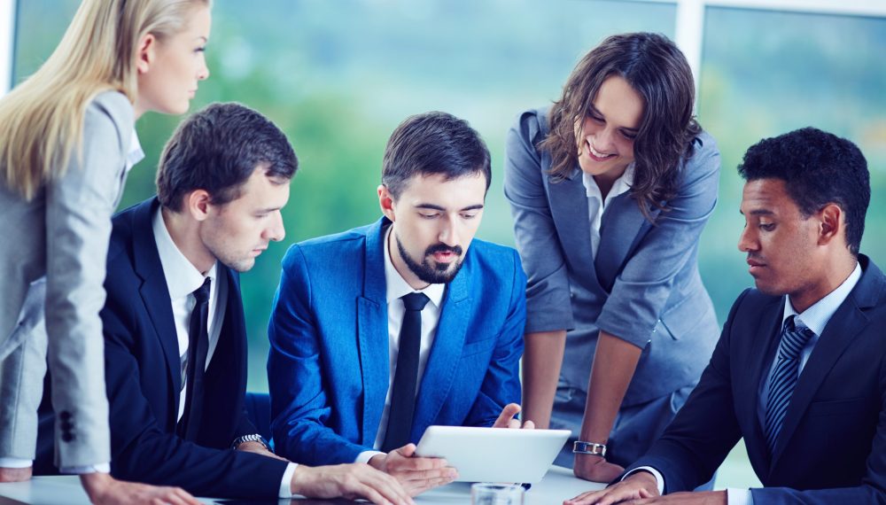 Several confident employees gathered at workplace discussing data