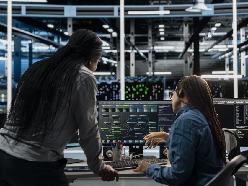 Server room manager overseeing work done by engineer using artificial intelligence to reduce downtime. Team leader supervising employee implementing AI driven solutions for data center equipment